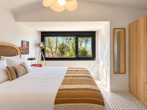 Dormitorio moderno en la casita El Román, Baiona con vistas al mar a través de grandes ventanales, muebles de madera y ropa de cama a rayas