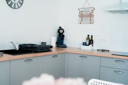 Modern kitchen in Sydney apartment at Résidence des Sables, Mably with wooden counters and grey cabinetry