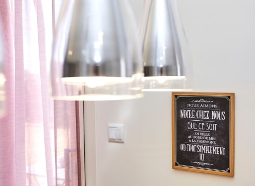Cozy apartment interior at Résidence des Sables with pink curtains, pendant lights, and French welcoming sign on wall