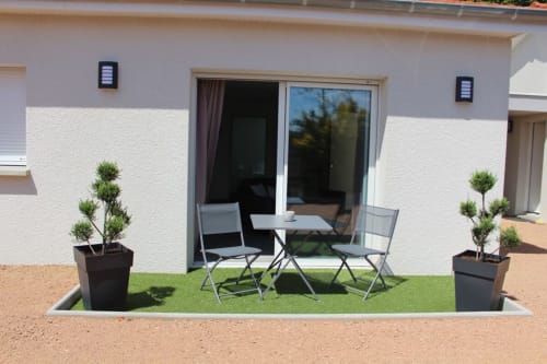 Apartment 3 terrace at Résidence des Sables with seating area, potted topiaries, and inner courtyard view in Mably.
