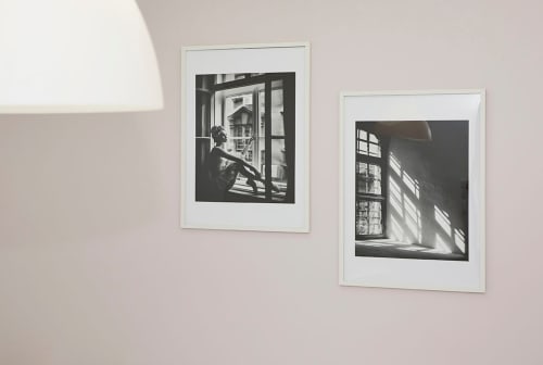 Two framed black and white photographs featuring windows with natural light at Résidence des Sables Paris apartment