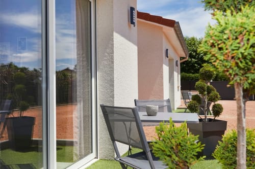 Modern patio at Résidence des Sables, Mably with courtyard view, seating, and manicured garden