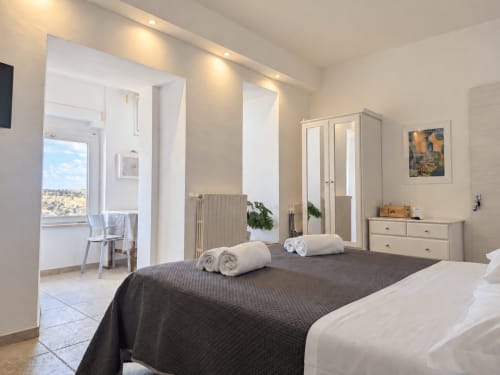 Deluxe Room Eva at Il Peccato Originale in Matera with double bed and view towards the Murgia