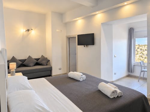 Camera Eva with double bed, sofa area, TV and view over the Murgia Materana