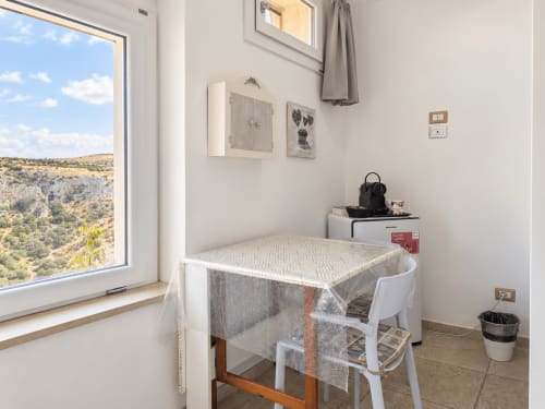 Breakfast corner with fridge and coffee corner in Camera Eva beside the window overlooking the Gravina and Sassi