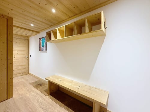 Vestiaire moderne de l'appartement de Montgenèvre avec casiers en bois, rangements sur banc et entrée aménagée pour le ski
