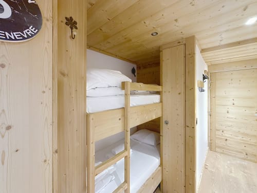 Lit superposé en bois avec draps blancs dans la chambre compacte de l'appartement alpin Les Tanières de Montgenèvre