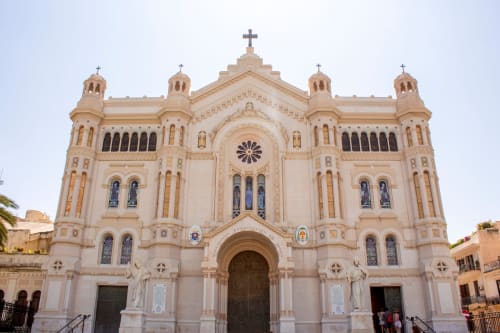 Cattedrale ornata con facciata color crema e croci a Reggio Calabria