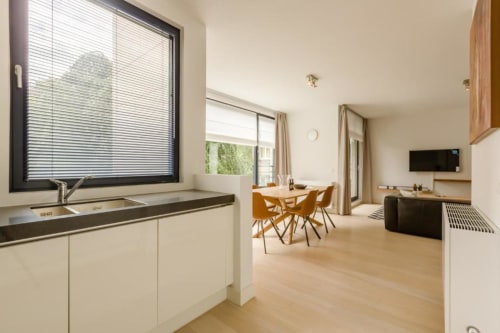 Appartement moderne à Bruxelles avec séjour ouvert, cuisine, salle à manger, parquet et design minimaliste