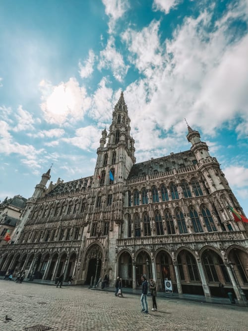 Imposante cathédrale gothique avec sa haute flèche dominant la place de Bruxelles, Belgique, sous un ciel bleu