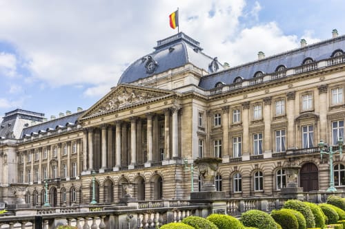 L'hôtel Livorno à Bruxelles présente une architecture néoclassique majestueuse avec des colonnes ornées et un toit mansardé surmonté d'un