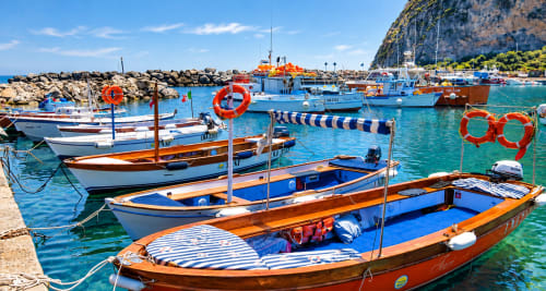 Barche da pesca colorate in acque turchesi presso Serrara Fontana, Italia, che catturano il fascino costiero mediterraneo