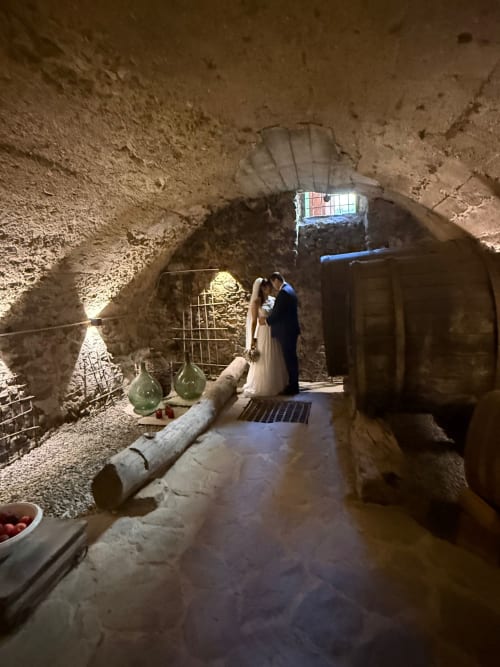 Bride and groom kissing in historic stone cellar at Roseto del Drago, Ponte In Valtellina