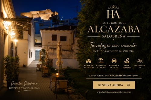 Patio nocturno del Hotel Boutique Alcazaba Salobreña con edificios encalados iluminados y vistas al castillo
