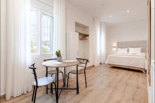 Suite espaciosa del hotel Alcazaba Salobreña con comedor, cama y ventanales panorámicos con vistas a Granada
