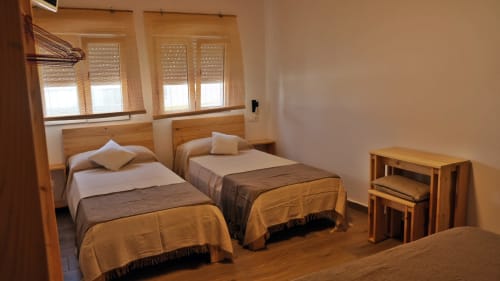 Habitación cuádruple Cal Xot B&B en Poble Nou con camas gemelas, muebles de madera, ventanas con persianas y televisión