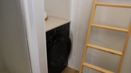 Lavadora negra de carga frontal en la lavandería de Cal Xot B&B, Poble Nou