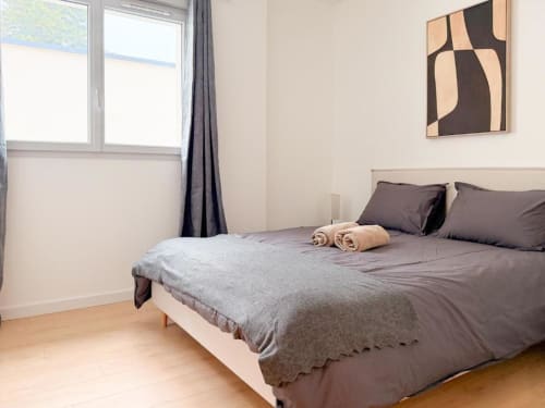Helles Schlafzimmer im Vindihouses BnB Epinac mit Doppelbett, moderner Kunst, Holzböden und großen Fenstern