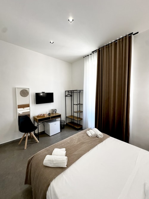 Camera moderna presso I colori di Napoli B&B a Napoli con letto matrimoniale, TV, scrivania e tende con vista sulla città