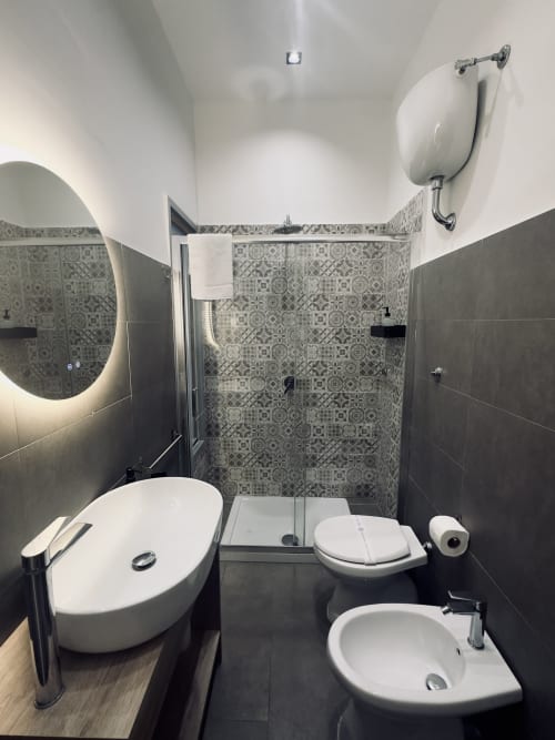 Bagno moderno presso I colori di Napoli B&B con doccia, WC, lavabo, specchio riscaldato e piastrelle decorate