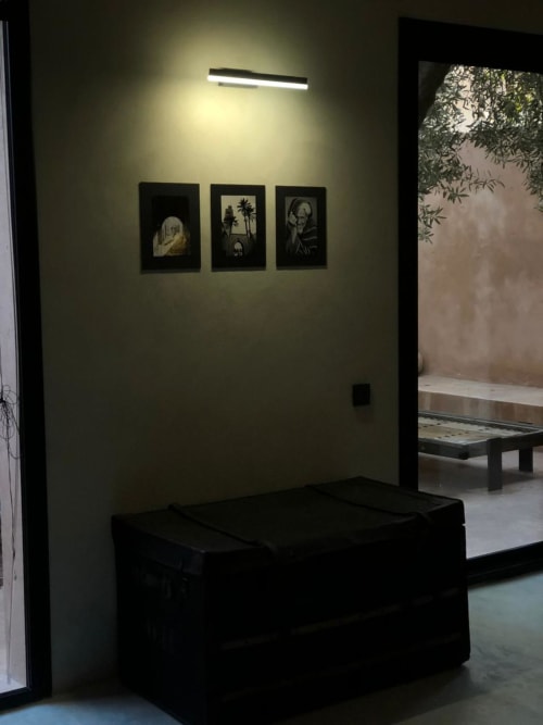 Suite moderne du Jardin Sakina Marrakech avec banc noir, trois œuvres d'art encadrées sur mur crème et design contemporain