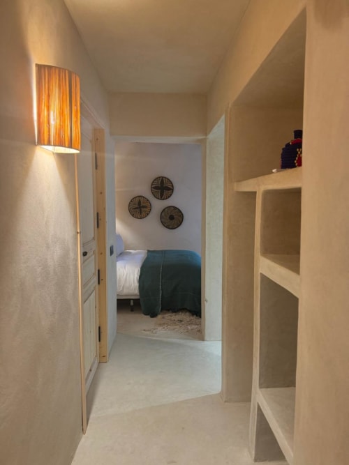 Couloir moderne menant à la chambre de la Suite Beldi à l'hôtel Jardin Sakina à Marrakech, avec éclairage ambiant