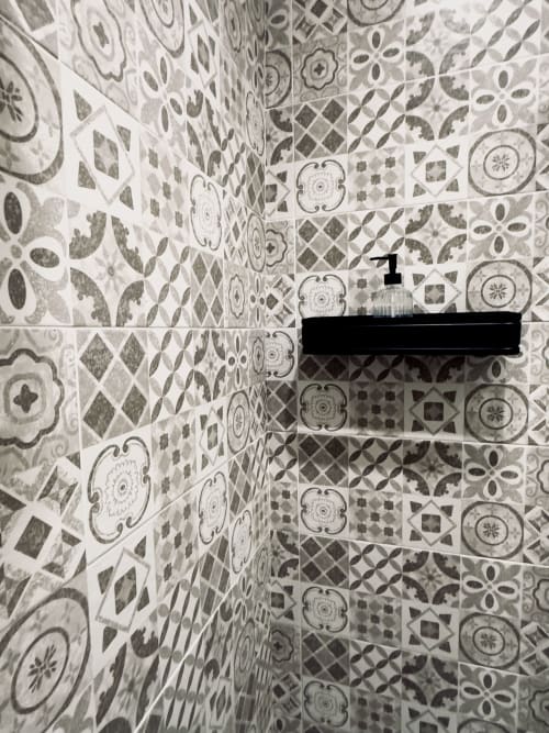 Piastrelle decorative con motivi geometrici classici in grigio e bianco nella camera di una B&B a Napoli