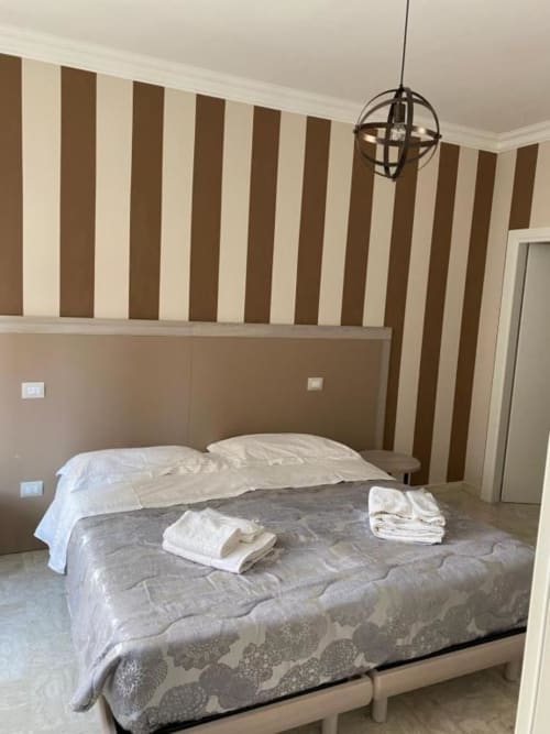 Camera da letto in Suite in Città Depandance, Isernia: pareti righe marrone e crema, lampada a sospensione, vista città
