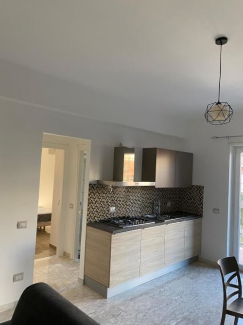 Cucina moderna nell'appartamento Ambra presso Suite in Città Depandance, Isernia con mobili in legno chiaro, piano cottura nero e design geometrico