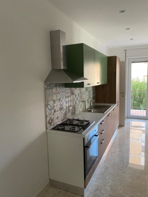 Cucina moderna nell'appartamento Giada di Suite in Città Depandance, Isernia, con piano cottura a gas, piastrelle decorate e verde