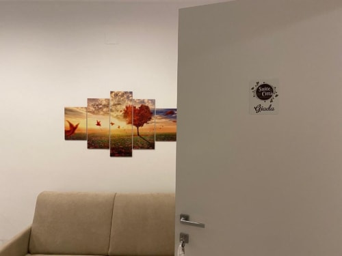 Appartamento Giada presso Suite in Città, Isernia con moderna arte murale dal design tramonto e alberi sopra divano beige
