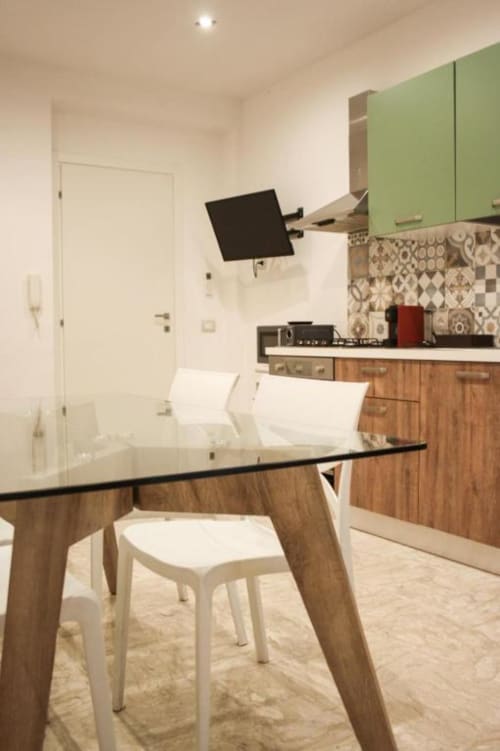 Moderna zona cucina-pranzo nell'appartamento Giada presso Suite in Città Depandance, Isernia con tavolo in legno, sedie bianche, verde