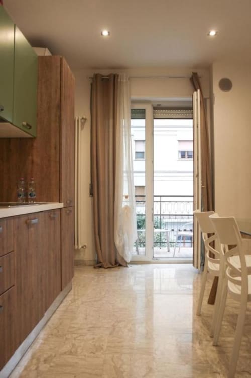 Moderna zona cucina-pranzo nell'appartamento Giada presso Suite in Città Depandance, Isernia, con mobili in legno, accesso al balcone e