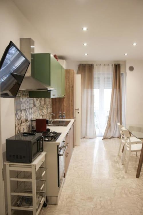 Cucina moderna nell'appartamento Giada di Suite in Città Depandance, Isernia, con mobili verdi, zona pranzo e balcone sulla città