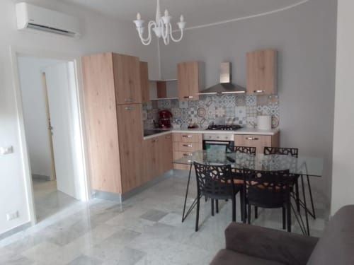Cucina e zona pranzo moderna nell'appartamento Ematite presso Suite in Città Depandance, Isernia, con mobili in legno e motivi decorativi