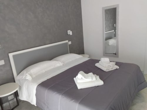 Camera da letto moderna presso Suite in Città Depandance, Isernia con cuscini bianchi e biancheria scura