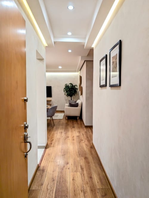 Pasillo moderno del apartamento Casa Donceles en Ciudad de México con pisos de madera, cuadros enmarcados y zona de entrada