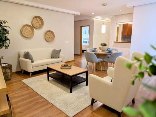Moderna sala de estar en Casa Donceles, apartamento en Ciudad de México con sofá crema, comedor, pisos de madera y decoración