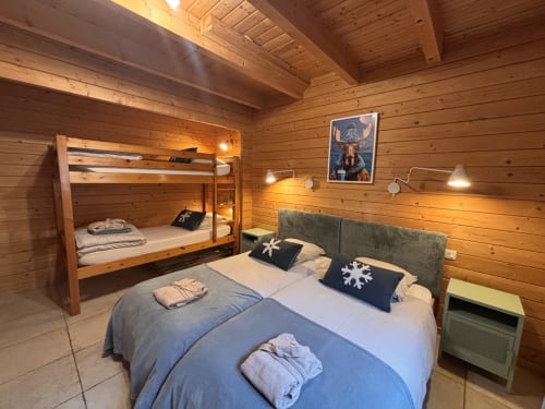 Chambre chaleureuse du chalet Les Chalets d'Aline à La Plagne avec lit queen-size et lits superposés