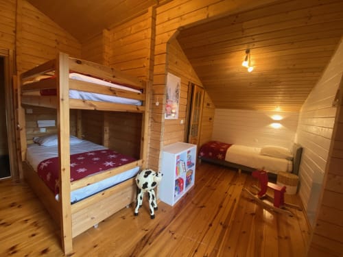 Chambre douillette de chalet en bois aux Chalets d'Aline à La Plagne avec lits superposés et cheminée