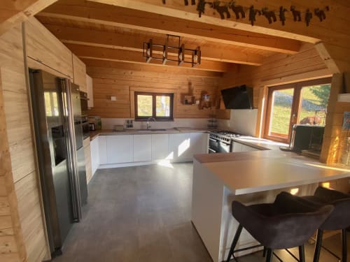 Cuisine moderne avec mobilier blanc et îlot dans le chalet Les Chalets d'Aline, La Plagne