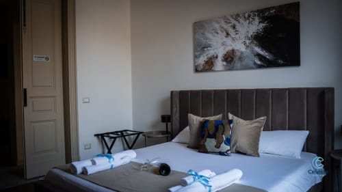 Camera moderna alle Moon Rooms By Celeste di Catania con testata scura, opere d'arte e servizi di benvenuto