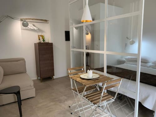 Moderno monolocale al B&B Il Giardino di Ulisse a Reggio Calabria con tavolo da pranzo, letto, divano e vetrata