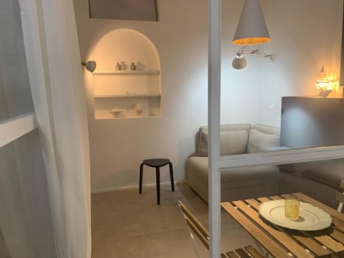Moderno appartamento bed & breakfast a Reggio Calabria con zona notte, nicchia ad arco, sgabello nero e illuminazione ambientale