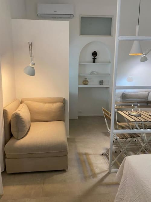 Moderno monolocale a Reggio Calabria con sedute confortevoli, mensole a parete, illuminazione a sospensione e design contemporaneo