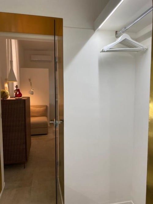 Moderna cabina armadio con armadiatura bianca integrata e binario appendiabiti a B&B Il Giardino di Ulisse, Reggio Calabria