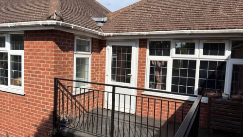 Modern brick furnished home in High Wycombe with white-framed windows, garden view patio, and metal railings