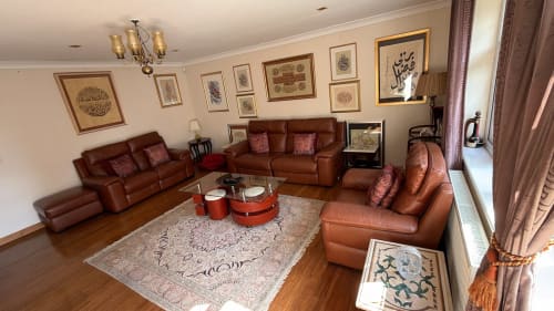 Elegant living room with brown leather sofas, patterned rug, framed artwork, and modern furnishings at England Furnished