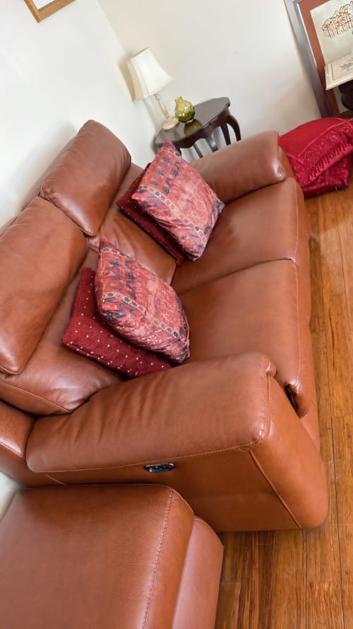 Brown leather reclining chair with red patterned cushions in England Furnished Homes High Wycombe property