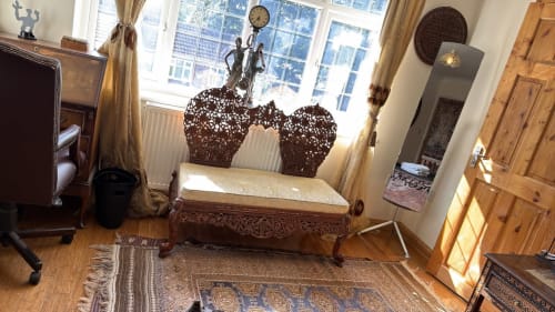 Elegant furnished bedroom at England Homes High Wycombe with carved wooden bed, ornate headboard, and natural garden views